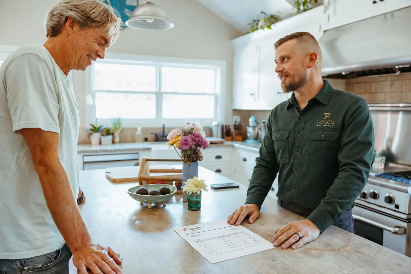 Eric Taysom talking a homeowner through paperwork at a kitchen counter